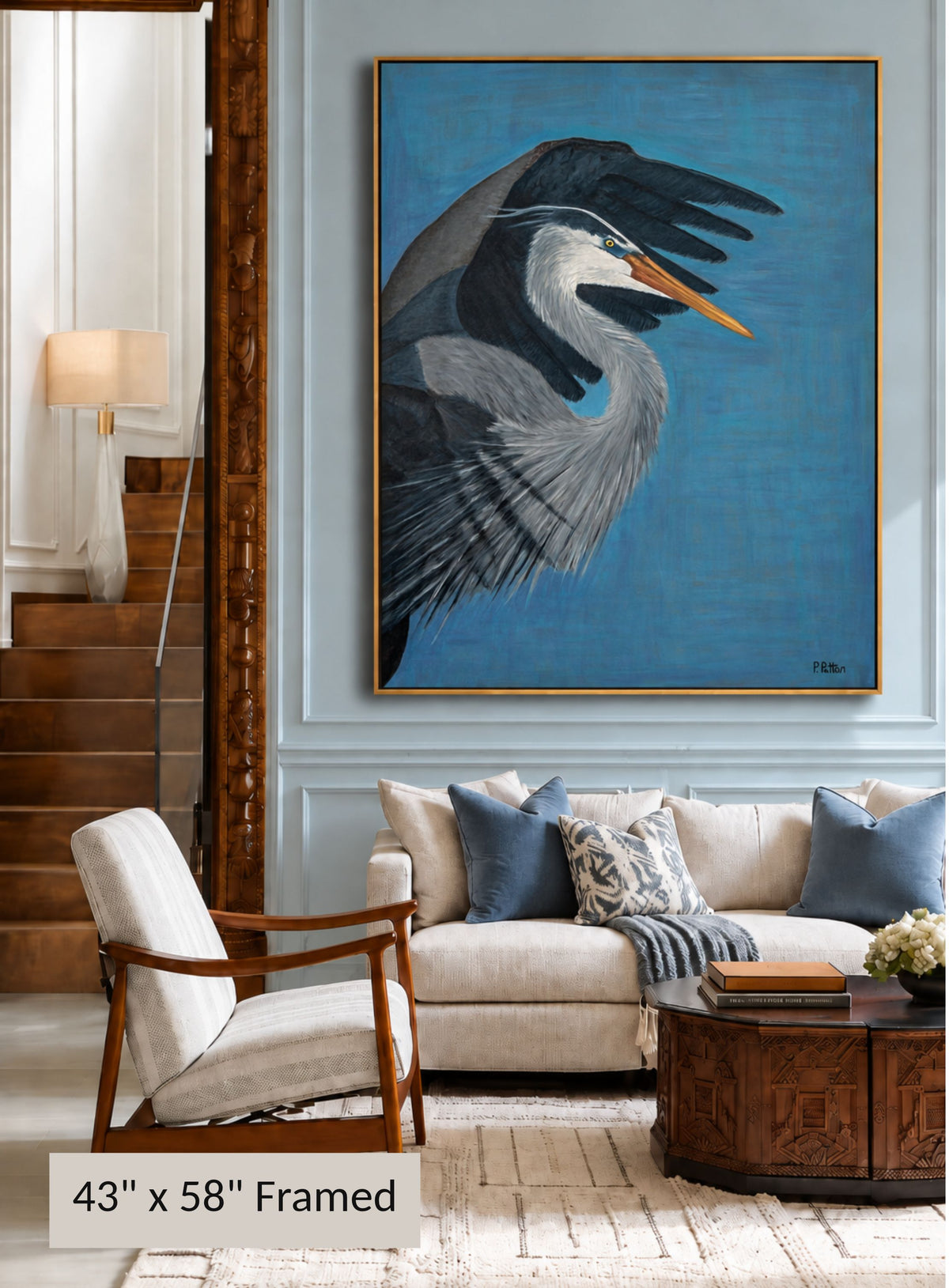 Wide Open — 43 × 58 inches, framed Designer Edition, blue heron displayed above a sofa in an elegant living room