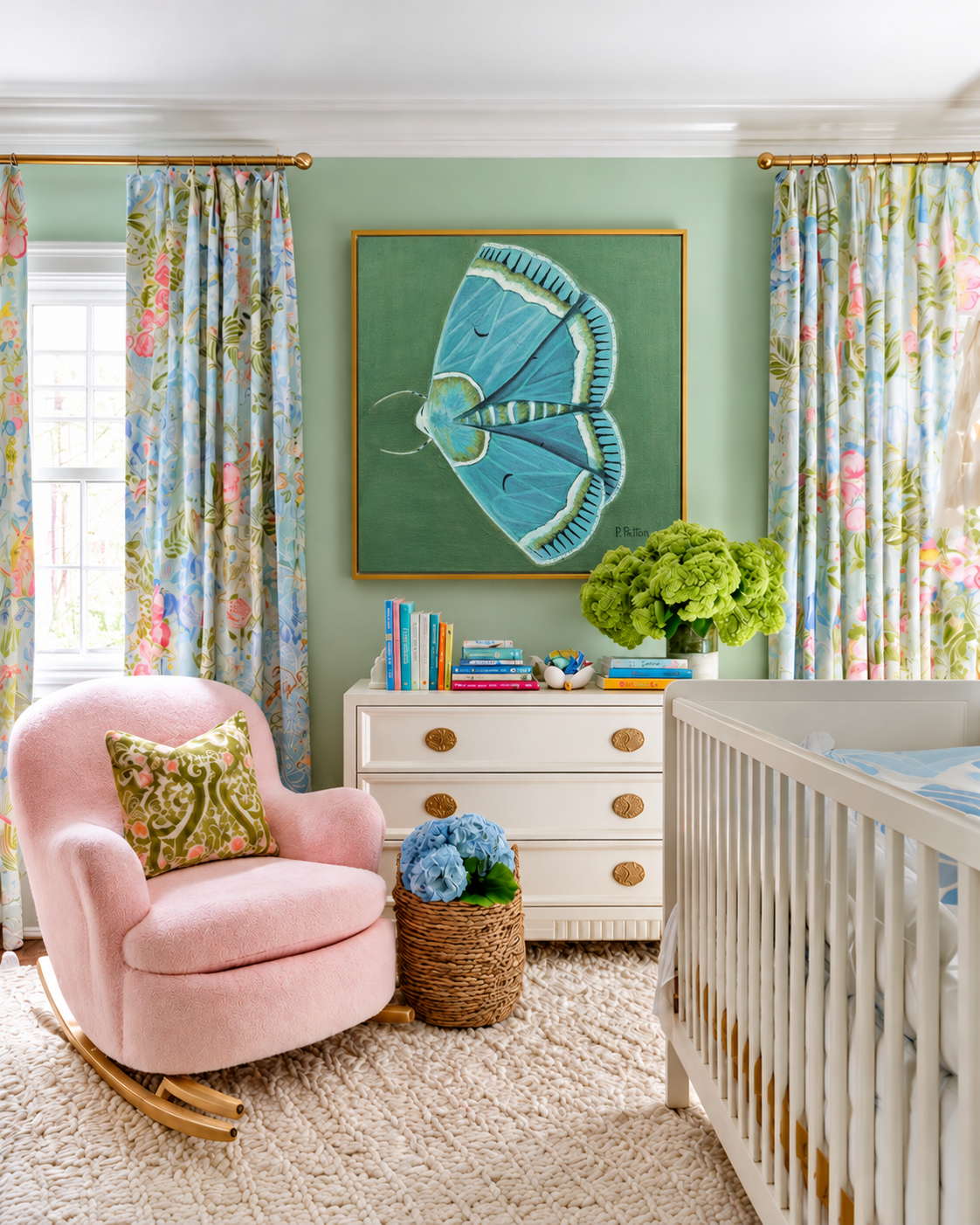Prudence blue-green moth artwork in a gold floating frame above a dresser in a bright pastel nursery